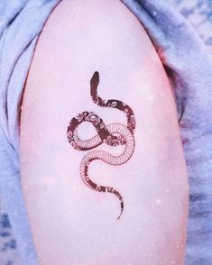 a woman's arm with a tattoo on it that is shaped like a snake