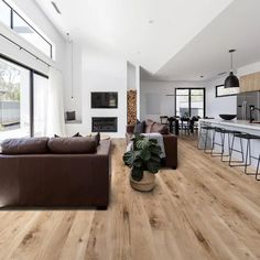 a living room filled with furniture next to a kitchen and an open concept dining area