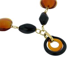 This gorgeous contemporary Murano Glass necklace in golden brown and black color palette features an exquisite design of concentric rings in the center suspended from a beaded necklace. This Italian necklace is an example of unique hand-made Murano Glass jewelry that demonstrates why Murano glass makers have been held in high regard around the world for ages. This versatile piece of Italian jewelry can be worn with your evening or casual outfits and will add Venetian elegance and Italian style t Elegant Brown Round Necklace, Elegant Brown Round Necklaces, Modern Brown Round Jewelry, Italian Necklace, Black Color Palette, Italian Leather Handbags, Murano Glass Necklaces, Murano Glass Jewelry, Italian Bags