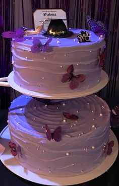 a three tiered cake with purple butterflies on it