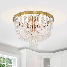 a chandelier hanging from the ceiling in a white and gold colored living room