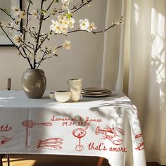 a vase with some flowers in it on a table next to a plate and cup