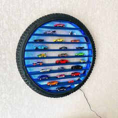 a toy car display in the shape of a tire with cars on it and wires attached