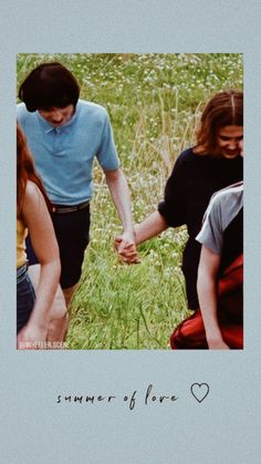 two young people holding hands while standing in a grassy field with the words summer of love written on it