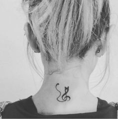 a black and white photo of a woman's neck with a musical note tattoo on it