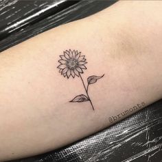 a small sunflower tattoo on the arm