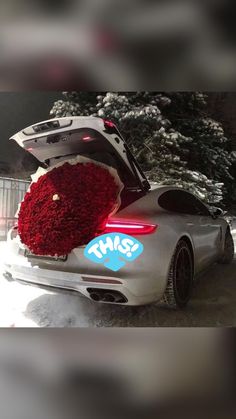 the back end of a silver sports car covered in flowers