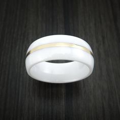 This 8mm wide WHITE CERAMIC band has a high-polish finish and features a 1mm centered 14k Yellow Gold inlay. Each ring is custom made and your ring comes with a COMFORT-FIT for extra satisfaction. Our rings WILL not TARNISH or cause your skin to discolor. This ring can be fully customized! If you need to change any aspect of the ring, please contact us and we can help you out! If you have any other questions at all, please let us know! All rings will come with our standard Logo engraved on the i White 14k Gold Ring With Tension Setting, 14k Gold White Ring With Tension Setting, Modern White 14k Gold Ring, Classic White Wide Band Ring, Elegant White Wide Band Promise Ring, White Open Band Ring With Polished Finish, White Open Band Rings With Polished Finish, White Open Band Jewelry With Polished Finish, Modern Wide Band Promise Ring