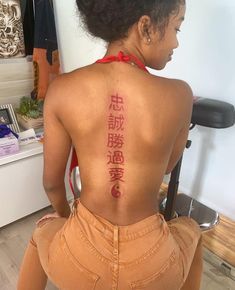 the back of a woman's body with chinese writing on her upper and lower back