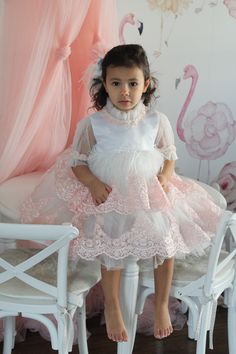 Petite Maison Kids. Gorgeous occasion dress in white color with peachy pink lace embroidery. Feathers on waistline. Faux Mother of Pearl beading. Multiple layers of tulle. Cotton lining on bodice. Back zipper closure. Wedding Dress With Pearl Embroidery In Tulle, Wedding Dress With Pearl Embroidery And Tulle, Organza Evening Dress With Pearl Embroidery, Pearl Embroidery Organza Evening Dress, Pink Tulle Dress For Ceremony, Elegant Floral Applique Dress For Ceremony, Elegant Floral Applique Ceremony Dress, Elegant Ceremony Dress With Floral Applique, Pink Ruffled Lace Dress For Party