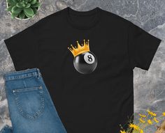 8 Ball Vintage 90s T-Shirt, 8 Ball Graphic Shirt, Billard Graphic Tee, 90s Unisex Oversized Top, Billard Gift, 8 Ball Shirt. The 100% cotton unisex classic tee will help you land a more structured look. It sits nicely, maintains sharp lines around the edges, and goes perfectly with layered streetwear outfits. Plus, it's extra trendy now!   * 100% cotton  * Sport Grey is 90% cotton, 10% polyester  * Ash Grey is 99% cotton, 1% polyester  * Heather colors are 50% cotton, 50% polyester  * Fabric wei 8 Ball Graphic, 8 Ball Shirt, Balls Shirt, 8 Ball, Trendy Graphic Tees, Graphic Tees Vintage, Layered Streetwear, Oversized Top, Streetwear Outfits