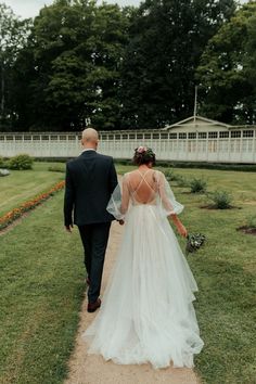 the bride and groom are walking down the path