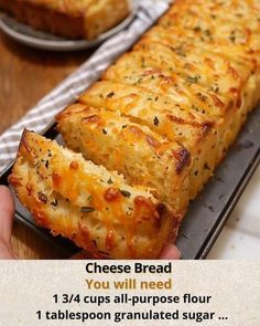 someone is holding up a cheesy bread that has been cut in half and placed on a baking sheet