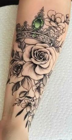 a woman's arm with flowers and a crown on it