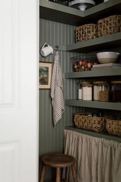 a kitchen with green walls and shelves filled with food