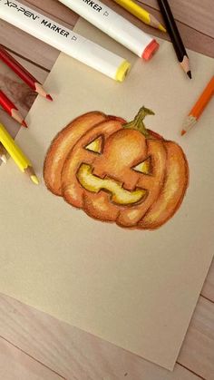 a drawing of a jack o lantern with crayons next to it