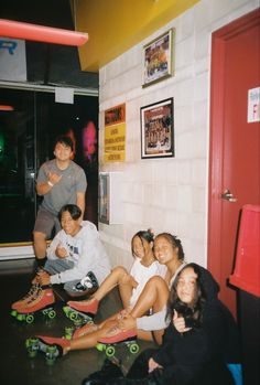 a group of young people sitting next to each other on skateboards