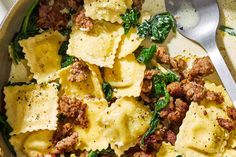 pasta with meat and spinach in a skillet next to a fork on a table