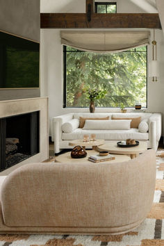 a living room filled with furniture and a fire place in front of a large window