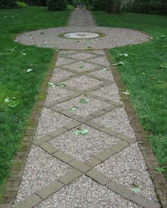 a stone path in the middle of a grassy area