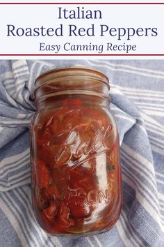 a jar filled with red peppers sitting on top of a blue and white striped cloth