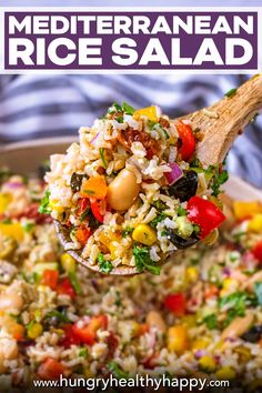 a wooden spoon filled with rice salad on top of a table