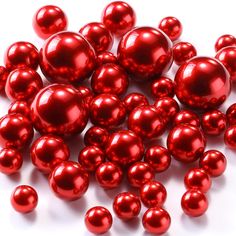 red pearls are scattered on a white surface