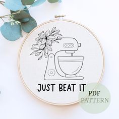 a embroidery pattern with the words just beat it and a hand mixer in front of flowers