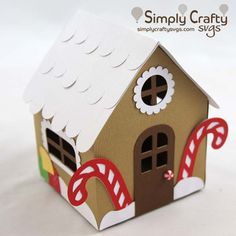 a gingerbread house made out of cardboard with candy canes on the roof and windows