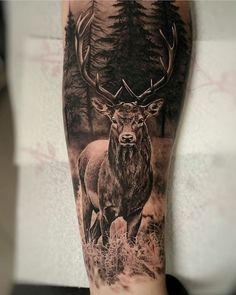 a man's leg with a deer and trees tattoo on the side of his arm