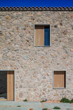 two windows on the side of a stone building