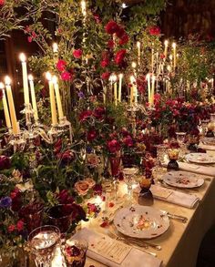 a long table with candles and flowers on it is set for a formal dinner or party