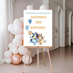 an easel with a birthday card on it next to balloons