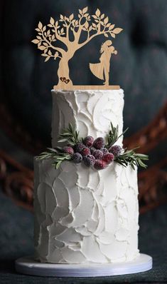 a white wedding cake with gold decoration on top and frosted icing in the shape of a tree