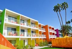 an apartment building with multicolored balconies and palm trees