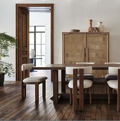 a dining room with wooden floors and white walls