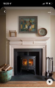 a fire place in a living room with a painting on the wall and a fireplace