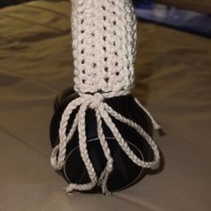 a white crocheted hat sitting on top of a black object in the middle of a table