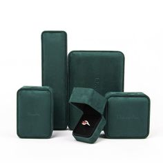 three pieces of green velvet jewelry cases with one open and the other closed, on a white background