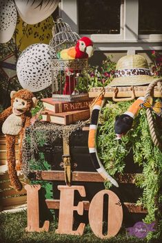 an assortment of hats, books and stuffed animals on display in front of a house