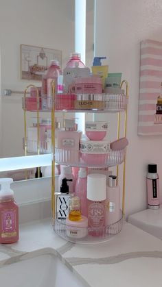 a bathroom with pink and gold accessories on the shelf next to the bath room sink