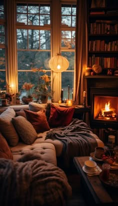 a living room filled with furniture and a fire place in front of a large window