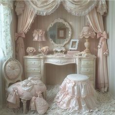 a white dressing table with a mirror, stool and other items on it in a room