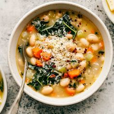 two bowls of white bean soup with spinach, carrots and parmesan cheese