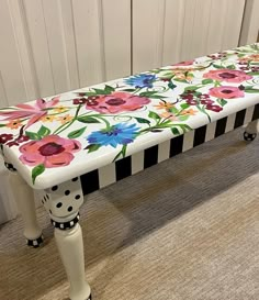 a white bench with flowers painted on it