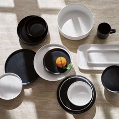 an assortment of black and white dishes on a table