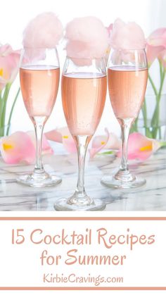 three champagne glasses filled with cotton candy on top of a table next to pink flowers