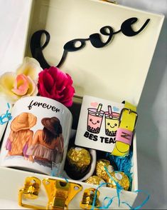 an open gift box filled with assorted candy and personalized items for someone's special occasion