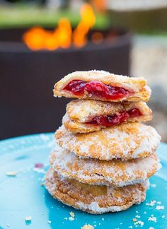 a stack of doughnuts sitting on top of a blue plate covered in powdered sugar