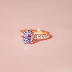 a pink diamond ring on a white surface